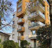 A building with balconies surrounded by trees and shrubs on Fazuľová Street in Bratislava - Old Town.
