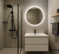 Bathroom with illuminated mirror and shower in a 2-room apartment.