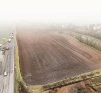 Commercial land in the town of Dudince, next to a busy road, with nearby amenities.