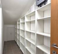 White storage space with shelves in a family house, tiles on the floor.