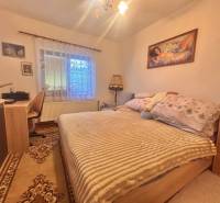Bedroom in a family house with a bed, a desk, and pictures on the walls.