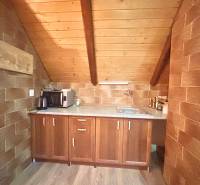 Attic kitchen in a family house with stone walls and wooden floor decor.