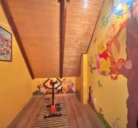 The attic of a family house with wooden decor and a children's painting featuring Disney characters.