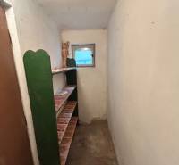Compact hallway with shelves and a small window in a family house.