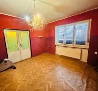 A room in a family house with a chandelier and a floor with a wooden decor.
