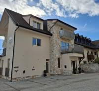 A recreational apartment in Starý Smokovec with rock elements and balconies against the backdrop of a blue sky.