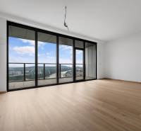 A spacious living area with large windows and wood-patterned flooring in a 3-room apartment.