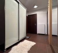 Entrance hall in a 2-room apartment with a built-in wardrobe and a white carpet on the floor.