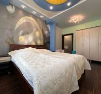 Bedroom in a 2-room apartment with a bed, cabinets, and a floor with a wood decor.