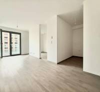 A bright living room in a two-room apartment with a wooden decor floor.