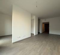 Interior of a 2-room apartment with a wooden decor floor and white walls.