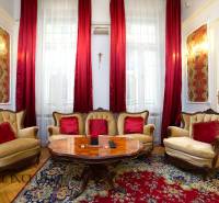 Traditional interior of a 2-room apartment with upholstered furniture and wood-patterned flooring.
