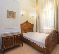 Bedroom in a 2-room apartment with a bed and a wooden decor floor.