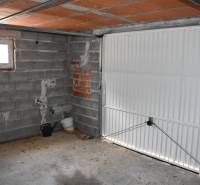 A garage in a family house in Pridraga with a concrete floor and white doors.