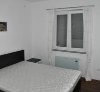 Bedroom with a bed, a painting on the wall, and a floor with a wooden decor.