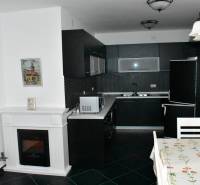 A kitchen in a family house with a black countertop and a dining table.
