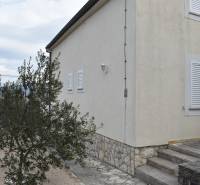 The exterior of a family house in Pridraga with a light facade and stone cladding.
