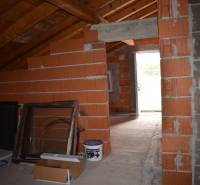 Unfinished attic interior with brick walls in a family house.