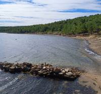 The coastal landscape near Pridraga with a forest, a shallow beach, and a rocky promontory.