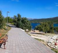 Coastal road in Pridraga with a bench, greenery, and a view of the sea.