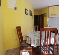 A kitchen in a family house with a dining table and yellow walls.