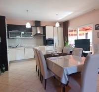 Dining area with seating and kitchen in a family house with wall decorations.