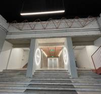 Interior with marble stairs, an area with elevators, and industrial details.