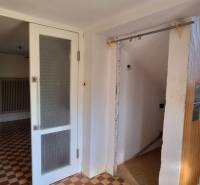 Interior of a family house with tiles, staircase, and glass partition.