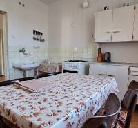 A kitchen in a family house with a dining table, a counter, and a stove.
