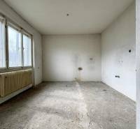 Empty room in a family house with a concrete floor and large windows.