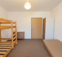 A bedroom in a 3-room apartment with a bunk bed and a sofa, neutral design.