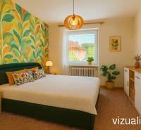A bedroom in a 3-room apartment with colorful wallpaper and a comfortable double bed.