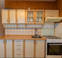 A kitchen in a 3-room apartment with a gas stove and wooden cabinets.