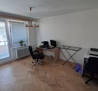 Home office in a 3-room apartment, wooden decor flooring, desks, chairs.