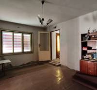 A room in a family house with simple furniture and a ceiling lamp.