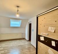 A room in a family house with a wooden decor floor and a built-in wardrobe.
