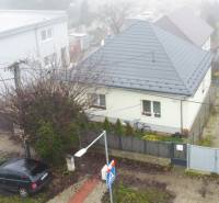 A family house on Trnavská Street in Bernolákovo surrounded by a garden and parked cars.