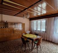Living room in a family house with wooden decor and a large glass cabinet.