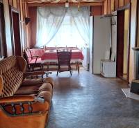 Living room in a family house with a sofa, stove, and round table.