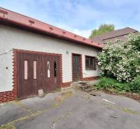 A family house in Nová Bašta with a wooden entrance and a flower garden.