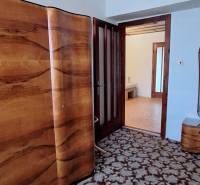 Family house with a floral patterned carpet, wooden doors, and a decorative chandelier.