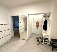 Hallway in a 4-room apartment with tiles, a shoe cabinet, and wall hooks.