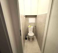 A bathroom with a toilet and tiles in a 4-room apartment.