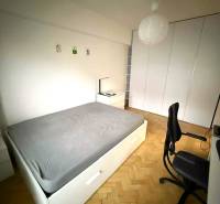 Bedroom with a built-in wardrobe and bed in a 4-room apartment, floor with wood decor.
