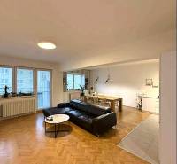 Living room of a 4-room apartment with a wooden decor floor and comfortable seating furniture.