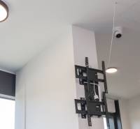 Ceiling with cameras, TV mount, and lighting in commercial premises.
