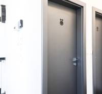 Interior of commercial premises with two doors marked with symbols and a kitchen unit.