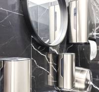 Bathroom commercial spaces with a mirror, black marble, and stainless steel dispensers.