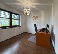 Office in a family house with a map on the wall, floor with wooden decor.