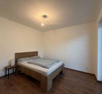 Bedroom with wood-patterned flooring and a comfortable bed in a family house.